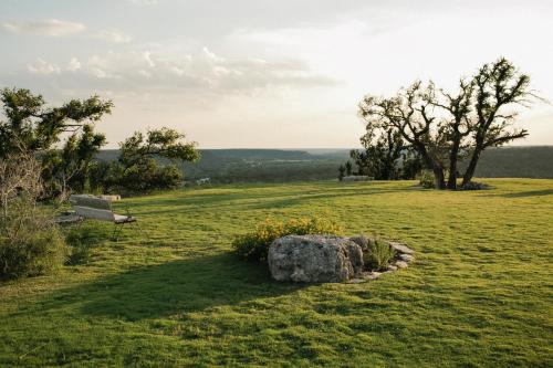 a park bench in a field with a rock at Contigo Ranch Fredericksburg in Fredericksburg