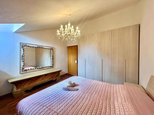 1 dormitorio con 1 cama grande y espejo grande en [Monzuno] Elegant Mansarda, en Monzuno