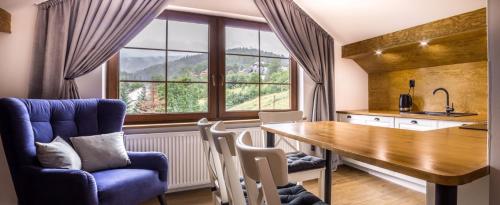 a kitchen with a table and chairs and a large window at Willa Maya in Karpacz