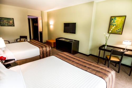 a hotel room with two beds and a desk at Lidotel Valencia in Valencia