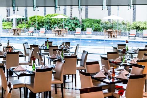 a restaurant with tables and chairs and a swimming pool at Lidotel Valencia in Valencia