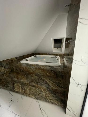 a bathroom with a tub on a marble counter at MAŁY KSIĄŻĘ in Podzamcze