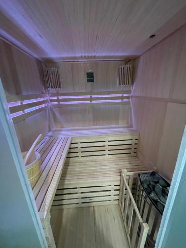 una sauna vacía con luces moradas en una habitación en MAŁY KSIĄŻĘ, en Podzamcze