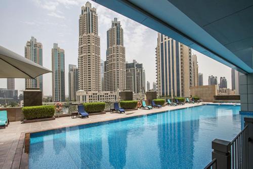 einen Pool mit Blick auf die Skyline der Stadt in der Unterkunft LUXFolio Retreats - Experience Luxury Living in Dubai