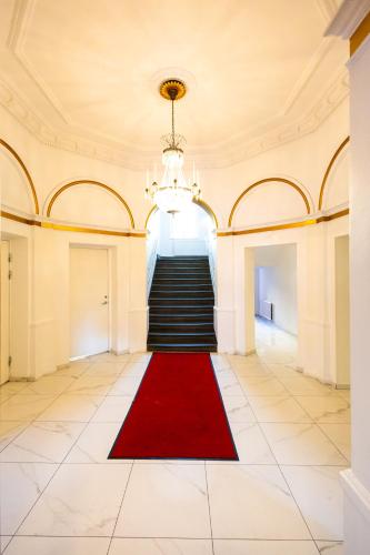 a hallway with a red carpet and stairs at Hotell Hjalmar in Örebro