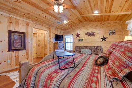 a bedroom with a bed and a tv in a cabin at Broken Bow Cabin with Hot Tub and Deck - 4 Mi to Lake! in Broken Bow