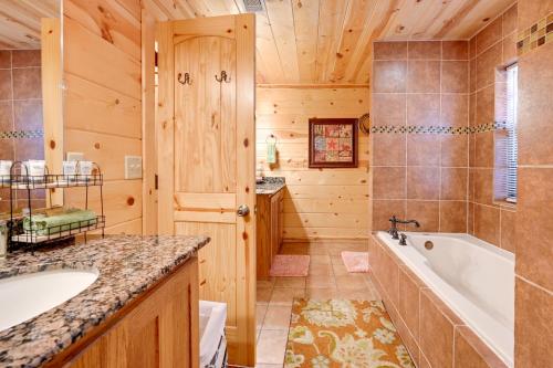 a log cabin bathroom with a tub and a sink at Broken Bow Cabin with Hot Tub and Deck - 4 Mi to Lake! in Broken Bow