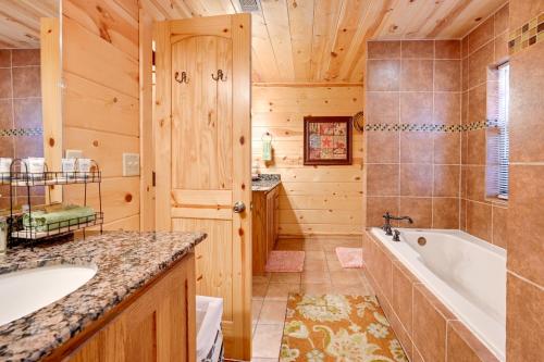 a log cabin bathroom with a tub and a sink at Lavish Cabin Hot Tub and Deck, Near Broken Bow Lake in Broken Bow