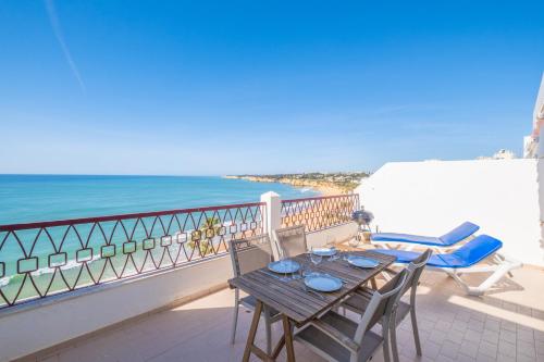 a table and chairs on a balcony overlooking the ocean at Frente ao Mar - 2 quartos - wi-fi in Armação de Pêra