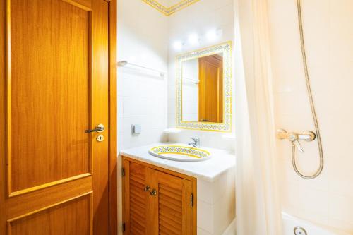 a bathroom with a sink and a mirror at Frente ao Mar - 2 quartos - wi-fi in Armação de Pêra