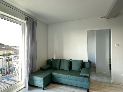 a living room with a couch and a large window at Apartament Szczecin in Szczecin