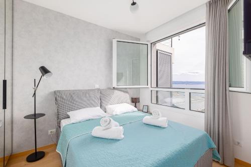 a bedroom with a bed with towels on it at Apartment ABIA Žnjan in Split