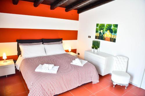 a red and white bedroom with a bed and a chair at Camere D'artista in Enna