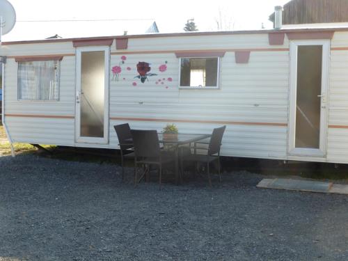 a table and chairs in front of a caravan at Hotel Gasthof Turm in Grünhaid