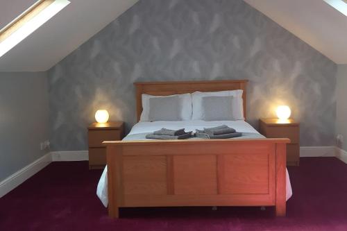 a bedroom with a bed with two lights on two night stands at The Cosy West Wing, dog friendly in Martham