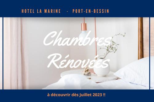 ein Bücherumschlag eines Schlafzimmers mit einem Bett und einem Tisch in der Unterkunft Le Grand Hôtel de la Marine in Port-en-Bessin-Huppain