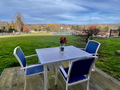 a table and chairs on a deck with a soccer field at F50 Ferme de Deauville 1 CH rez-de-jardin avec escalier in Saint-Arnoult
