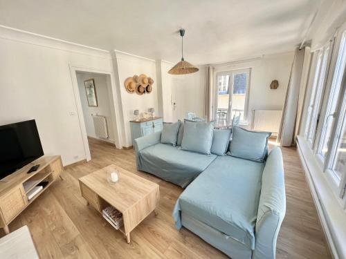un soggiorno con divano blu e TV di Le plage de Notre-Dame - Appartement au coeur de la vieille ville a Boulogne-sur-Mer