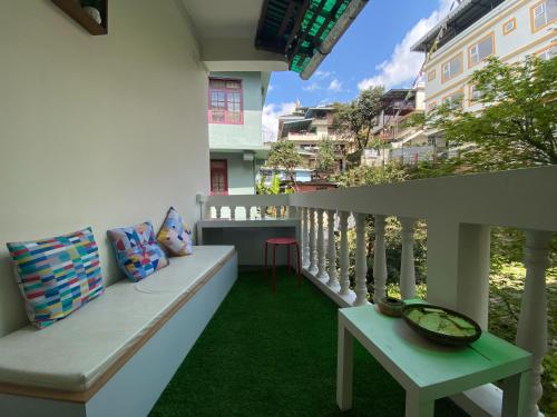 einen Balkon mit einer Bank und einem Tisch in der Unterkunft Tashila Hostel in Gangtok