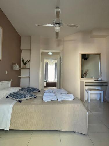 a bedroom with a large bed with towels on it at Andy’s apartments in Georgioupolis