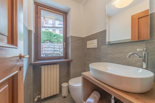 a bathroom with a sink and a toilet and a window at CASA JULIE - Accogliente rifugio nella quiete - COUR 0157 in Courmayeur