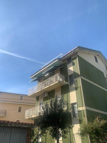 un edificio verde con balcones en un lateral en Casa Mare Calle en Casa Borgorosso