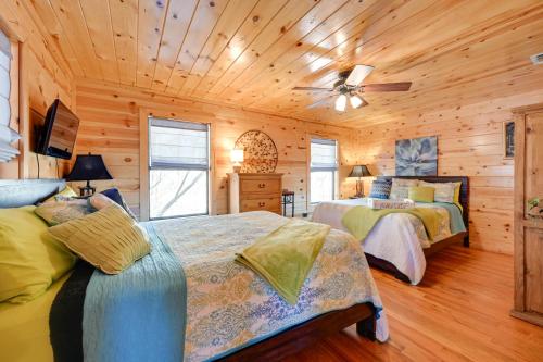 1 dormitorio con 2 camas y ventilador de techo en Broken Bow Cabin with Hot Tub and Fire Pit, en Broken Bow