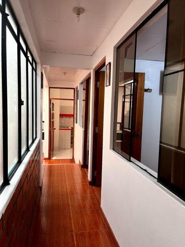 an empty hallway with windows and a wooden floor at Hospedaje Familiar Laos in Oxapampa