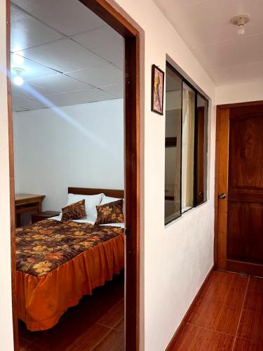 a bedroom with a bed and a glass door at Hospedaje Familiar Laos in Oxapampa