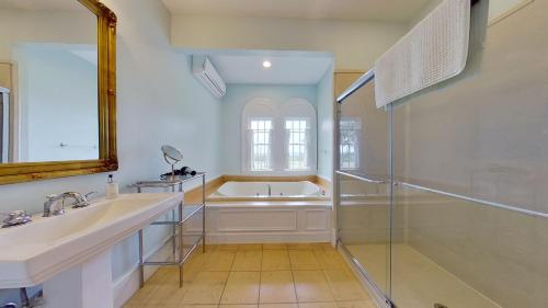 a bathroom with a tub and a sink and a shower at John Joseph Inn in Groton