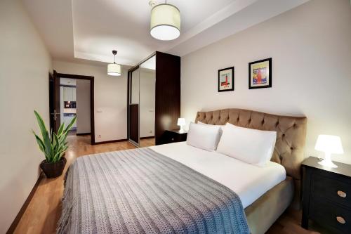 a bedroom with a large bed with white sheets at Luxury Residence in Şişli (Pool/Garage/Gym) in Istanbul