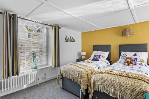 a bedroom with two beds and a window at Family Tides Brixham in Brixham