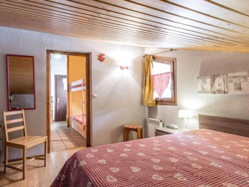 une chambre avec un lit et une chaise dans une pièce dans l'établissement Charmant 2 pièces avec cheminée, proche des pistes et commerces, garage inclus! - FR-1-304-85, à La Clusaz