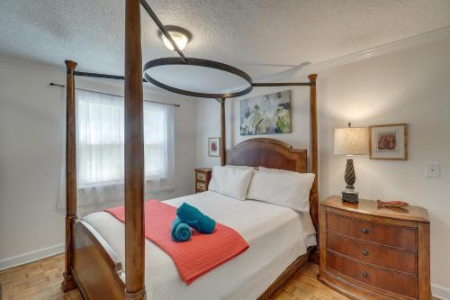 a bedroom with a four poster bed with two blue pillows at Beach Retreat in Jacksonville Pet and Family-Friendly in Jacksonville Beach