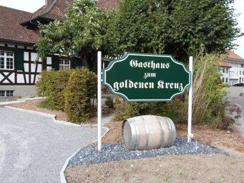 a street sign with a barrel in front of a house at Gasthaus zum Goldenen Kreuz in Rafz