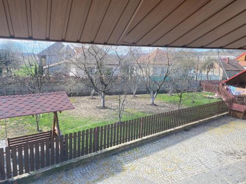 a fence with a bench in front of a park at Катерина in Chynadiyovo