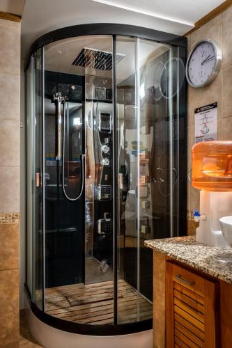 a glass shower in a kitchen with a clock on the wall at Manzano Resort in Villa La Angostura