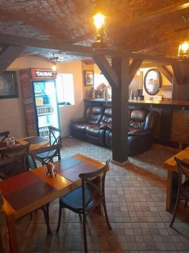 a restaurant with tables and chairs and a couch at Apartamentai, su nemokama vieta automobiliui in Saugos