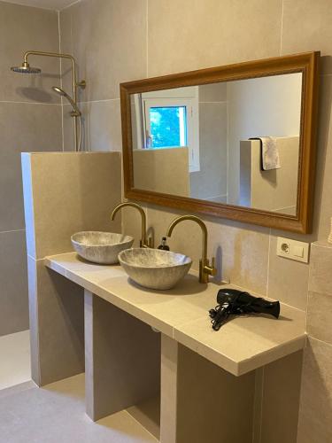 uma casa de banho com 2 lavatórios e um espelho em Casa El Sueño em Xàbia