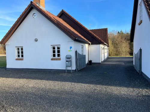 a white house with a red roof and a driveway at Auszeit im Grünen in Fårvang