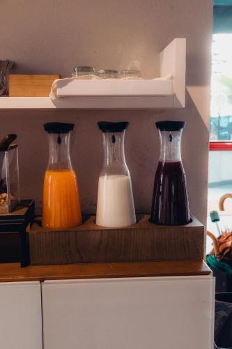three different colored vases sitting on a shelf at Albergo Centrale in Lamezia Terme