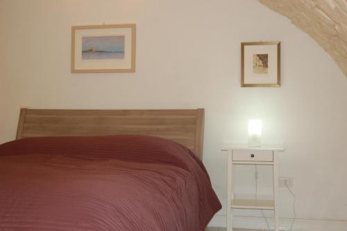 a bedroom with a bed and a white night stand at Profumo Di Gelsomino in Scicli