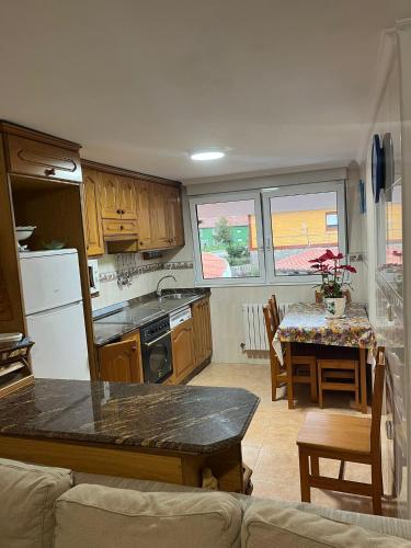 a kitchen and dining room with a table and a kitchen and a table and chairs at Apartamentos Joaquina in Tagle