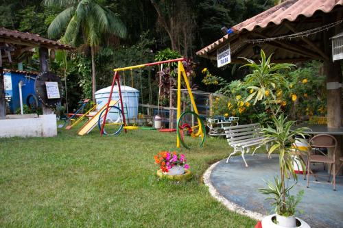 a backyard with a playground and a swing set at Pousada e Chalés Arco-Íris in Lima Duarte