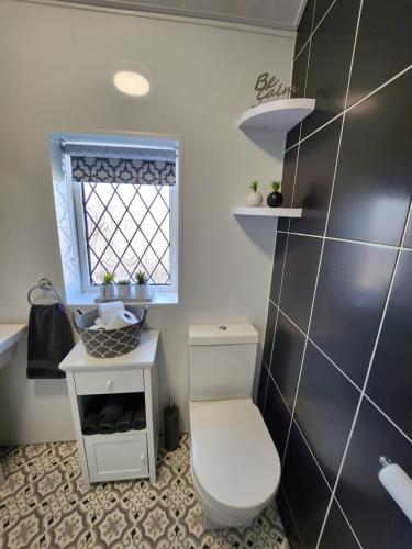 a bathroom with a toilet and a sink and a window at Delightful newly renovated 3-bed house with garden beach hut in Blackpool