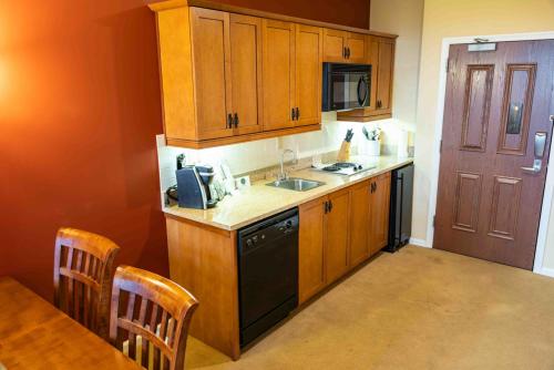 a kitchen with wooden cabinets and a sink and a table at The Appalachian at Mountain Creek in Vernon