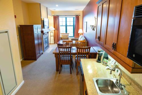 a kitchen with a sink and a table with chairs at The Appalachian at Mountain Creek in Vernon