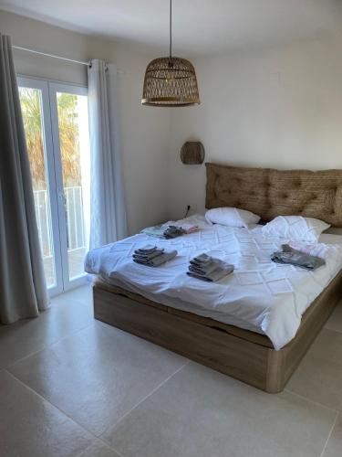 een slaapkamer met een groot bed met witte lakens bij Casa El Sueño in Jávea