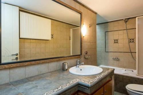 La salle de bains est pourvue d'un lavabo, d'un miroir et de toilettes. dans l'établissement Eleanna's Luxury Home, à Réthymnon