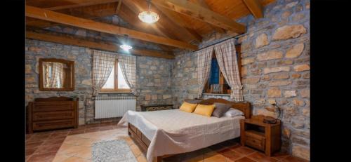 1 dormitorio con cama y pared de piedra en Villa Angela, en Poličnik